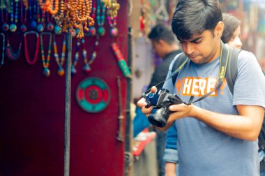 Hintli genç fotoğrafçı Hindistan 'ın tepedeki McCleodganj kasabasında kamerasına bakıyor.