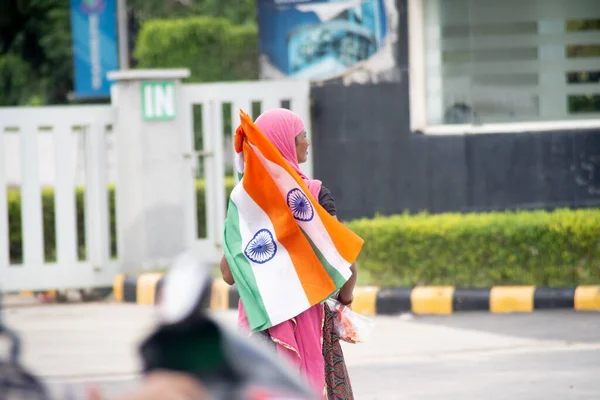 Szegény munkanélküli indiai nő, aki az indiai trikolor zászlót árulja az út szélén, a függetlenség indiai fesztiválján. — Stock Fotó