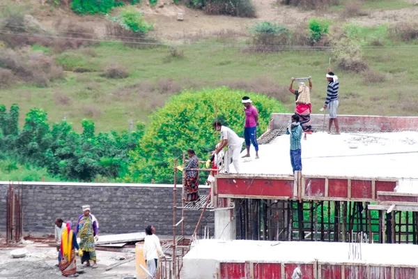 İnşaatın çatısının temelinde betonu karıştırarak ve bir insan zinciri kullanarak çatıya çıkarılarak zavallı bir yoksulluk içindeki işçinin döktüğü yere taşınması.