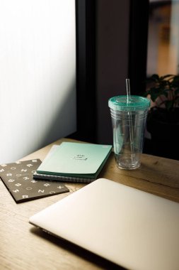 Not defteri kağıdı ve su dolu kupası olan yaratıcı insanlar için bir iş yeri.