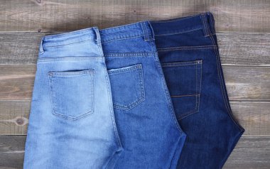 Yüksek bel pantolon üç çift kahverengi ahşap zemin üzerinde ikiye katlanır