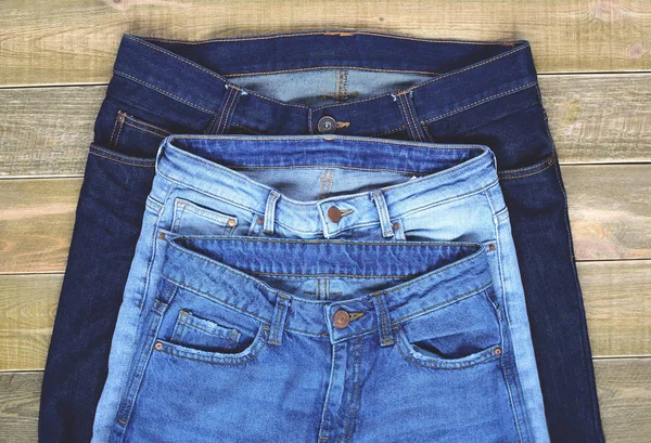 Ovanifrån Tre Par Hög Midja Jeans Framsida Brun Trä Bakgrund — Stockfoto