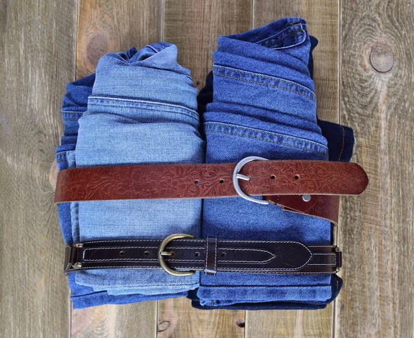 Vista Superior Uma Pilha Jeans Azul Dobrado Com Tiras Couro — Fotografia de Stock