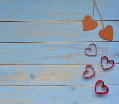 Sevgililer günü. 14 Şubat kavramı. Dize ve bir çok mavi vintage ahşap arka plan üzerinde kırmızı kalp iki ahşap kalp bağlı. Metin için yer.