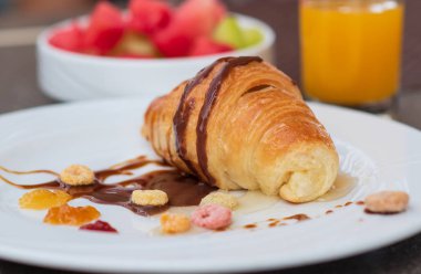 Taze kruvasan, portakal suyu ve meyveli Avrupa kahvaltısı.