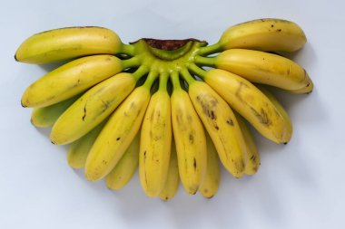 Beyaz arka planda küçük olgun muzlar.