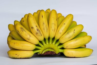 Beyaz arka planda küçük olgun muzlar.