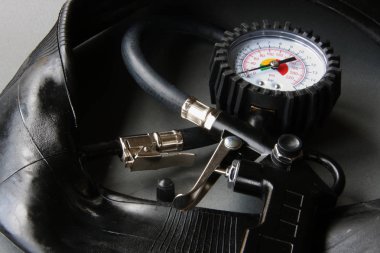 Gri arka plan lastikleri ile siyah gövdeli otomotiv manometre