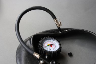 Gri arka plan lastikleri ile siyah gövdeli otomotiv manometre