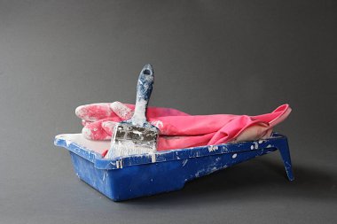 Mavi boya pot, fırça ve kırmızı lastik eldiven
