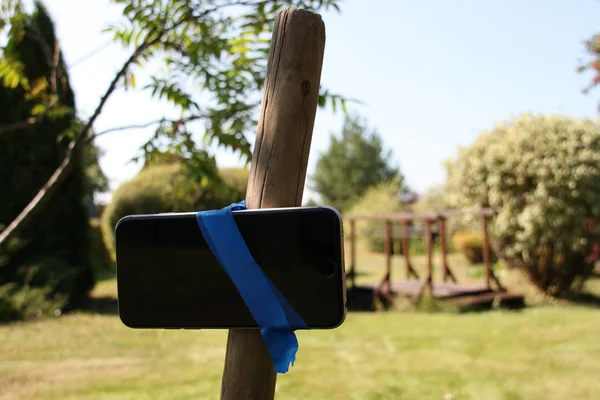 Smartphone Conectado Palo Sobre Fondo Jardín — Foto de Stock