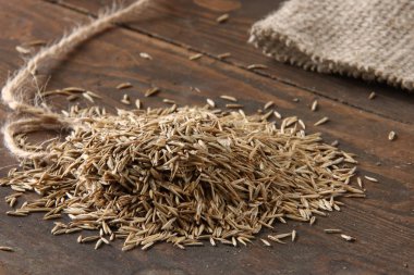 Kahverengi ahşap masa arkaplanındaki çimen tohumları 