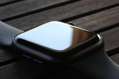 Siyah elektronik saat, siyah ahşap bir masa üzerinde.