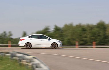 Güneşli bir günde yoldaki beyaz araba