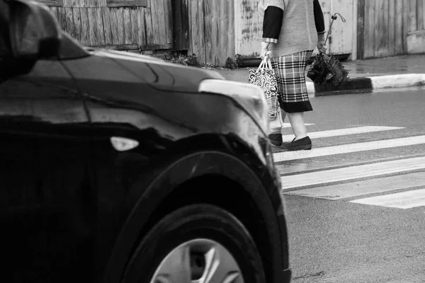 在十字路口一辆黑色汽车前的行人 — 图库照片