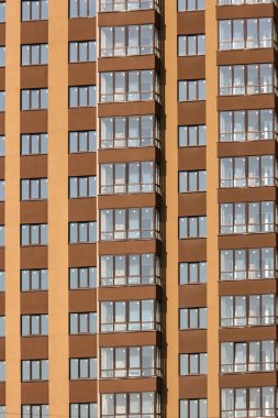 Bej ve kahverengi tonlarda çok katlı bir binanın ön cephesi