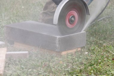 Gri toz kuru bir taş keserken bir disk ile