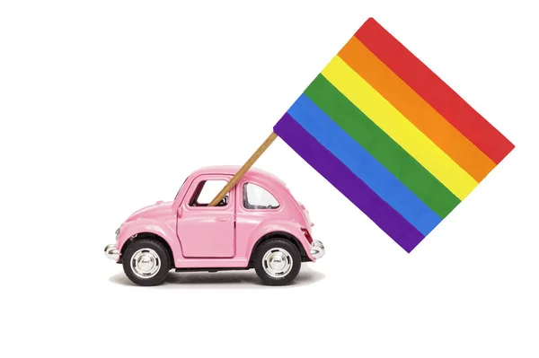 Pembe retro oyuncak araba parlak gökkuşağı eşcinsel bayrak teslim. Eşcinsel geçit töreni kavramı, Lgbt topluluğu ve insan hakları. Beyaz üzerine izole