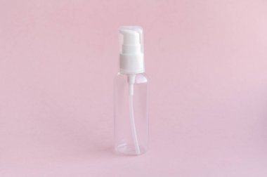 Yumuşak pembe arka plan üzerinde bir seyahat kullanmak için boş kavanoz. Tüm banyo malzemeleri, şampuan, losyon, tırnak vernik sökücü ve duş jelleri için. Yüz ve vücudun kadın güzelliği bakım anlayışı. Her zaman bir kadın çanta bulunan olacak küçük bir şey