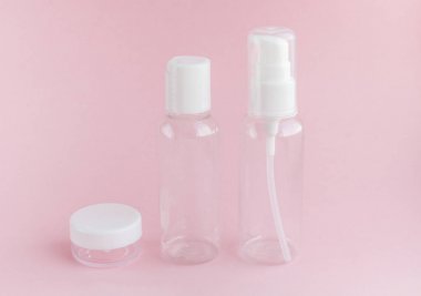 Yumuşak pembe arka plan üzerinde bir seyahat kullanmak için boş kavanoz seti. Tüm banyo malzemeleri, şampuan, losyon, tırnak vernik sökücü ve duş jelleri için. Yüz ve vücudun kadın güzelliği bakım anlayışı. Her zaman çanta içinde yer alacak küçük bir şey