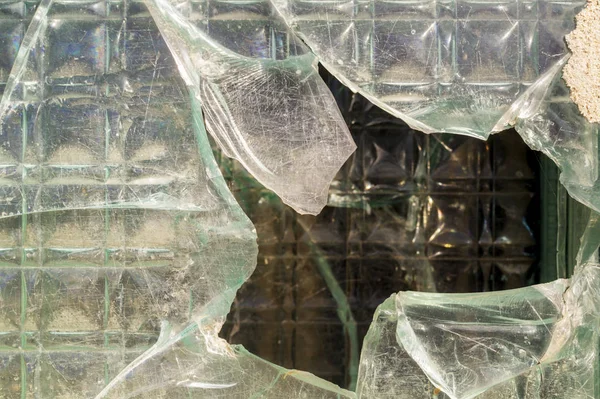 The thick, cracked glass of a window. The thick glass partition. Glass wall background. Glass texture and surface. Selective focus