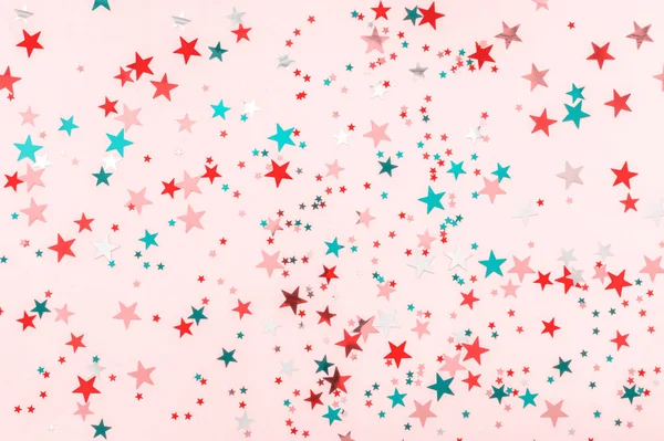 Πολύχρωμα αστέρια γκλίτερ σε ροζ φόντο. Εορταστική γιορτή σε παστέλ φόντο. Γιορτινή ιδέα. Διακοσμητικά Χριστούγεννα και το νέο έτος κόμμα φόντο. Κορυφή, επίπεδη όψη. Οριζόντια — Φωτογραφία Αρχείου