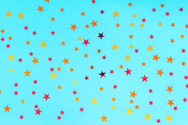 Conceito de celebração. Foto de estrelas multicoloridas polvilha no fundo azul. Fundo festivo de férias para seus projetos. Padrão de Natal. Vista superior, flat lay — Fotografia de Stock