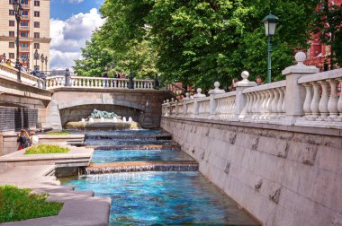 06 Temmuz 2019 Moskova, Rusya. Alexander Park ve Neglinnaya nehri. Metro Okhotny Ryad. Turistler ve yerliler yazın güneşli bir günde, çağlayan sularla dolu güzel bir çeşmede dinleniyorlar.