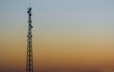 Gün batımında telekomünikasyon kulesi silueti