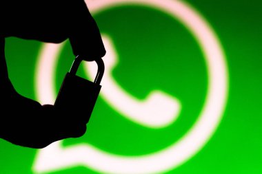 30 Haziran 2019, Brezilya. Bu fotoğraf illüstrasyon Whatsapp güvenlik kavramı. Whatsapp logosunun önünde asma kilit tutan bir elin silueti
