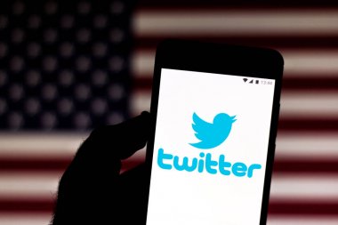 9 Temmuz 2019, Brezilya. Bu fotoğraf illüstrasyonda Twitter logosu bir akıllı telefonda görüntülenir. Arka planda, Amerika Birleşik Devletleri bayrağı