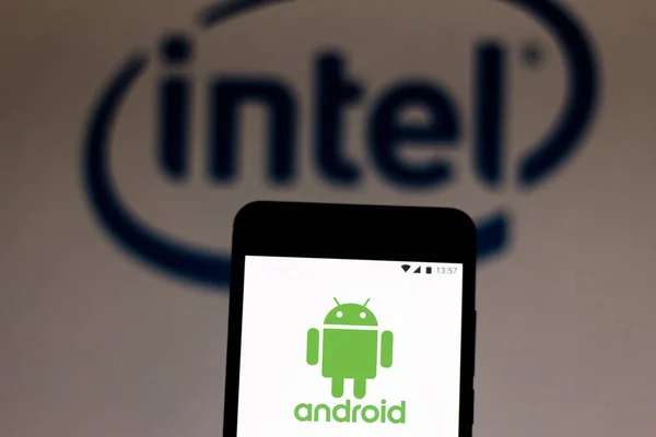 9 июля 2019 года, Бразилия. На этой фотографии логотип Android отображается на смартфоне. На заднем плане логотип Intel Corporation — стоковое фото