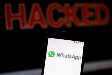 15 Ağustos 2019, Brezilya. Bu fotoğraf illüstrasyonda Whatsapp logosu bir akıllı telefonda ve bulanık arka planda Hacked sözcüğünde kırmızı uyarıda görüntülenir. Veri ihlali için kavramsal fotoğraf