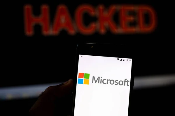 15 août 2019, Brésil. Dans cette illustration photo, le logo de Microsoft Corporation est affiché sur un smartphone et le mot d'alerte rouge HACKED sur le fond flou. Photo conceptuelle pour violation de données — Photo