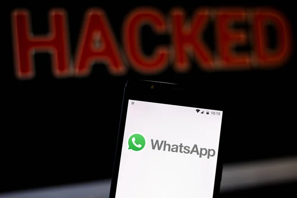 15 août 2019, Brésil. Dans cette illustration photo, le logo WhatsApp est affiché sur un smartphone et le mot d'alerte rouge HACKED sur le fond flou. Photo conceptuelle pour violation de données — Photo