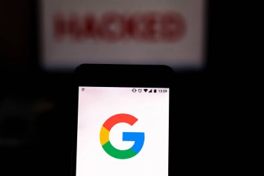 16 Ağustos 2019, Brezilya. Bu fotoğraf illüstrasyonunda Google logosu bir akıllı telefonda ve bulanık arka planda Hacked sözcüğünde kırmızı uyarıda görüntülenir. Veri ihlali için kavramsal fotoğraf