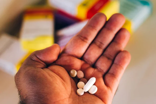 In this photo illustration Medicine capsules (pills) in sick patient's hand — Stock Photo, Image