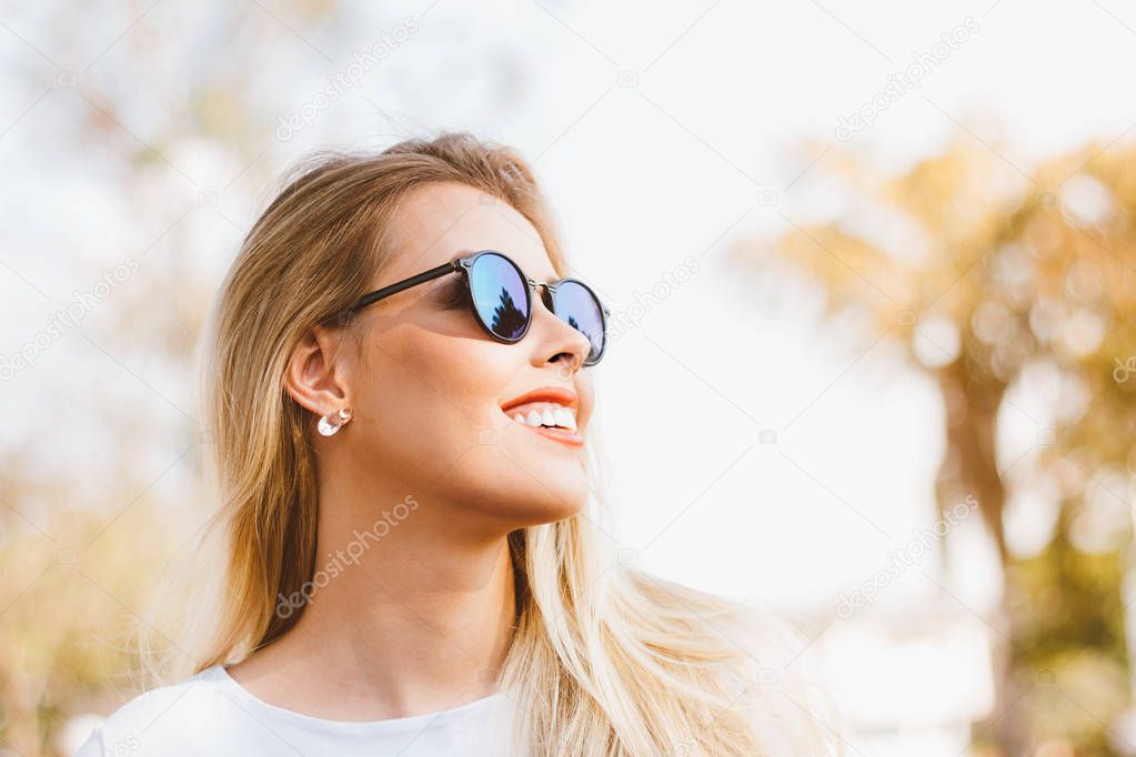 Outdoor fashion portrait of young smiling modern latin woman - Brazilian with retro sunglasses - Happy with the arrival of summer. Hot yellow filter. Fashion, trendy and millennial generation concept