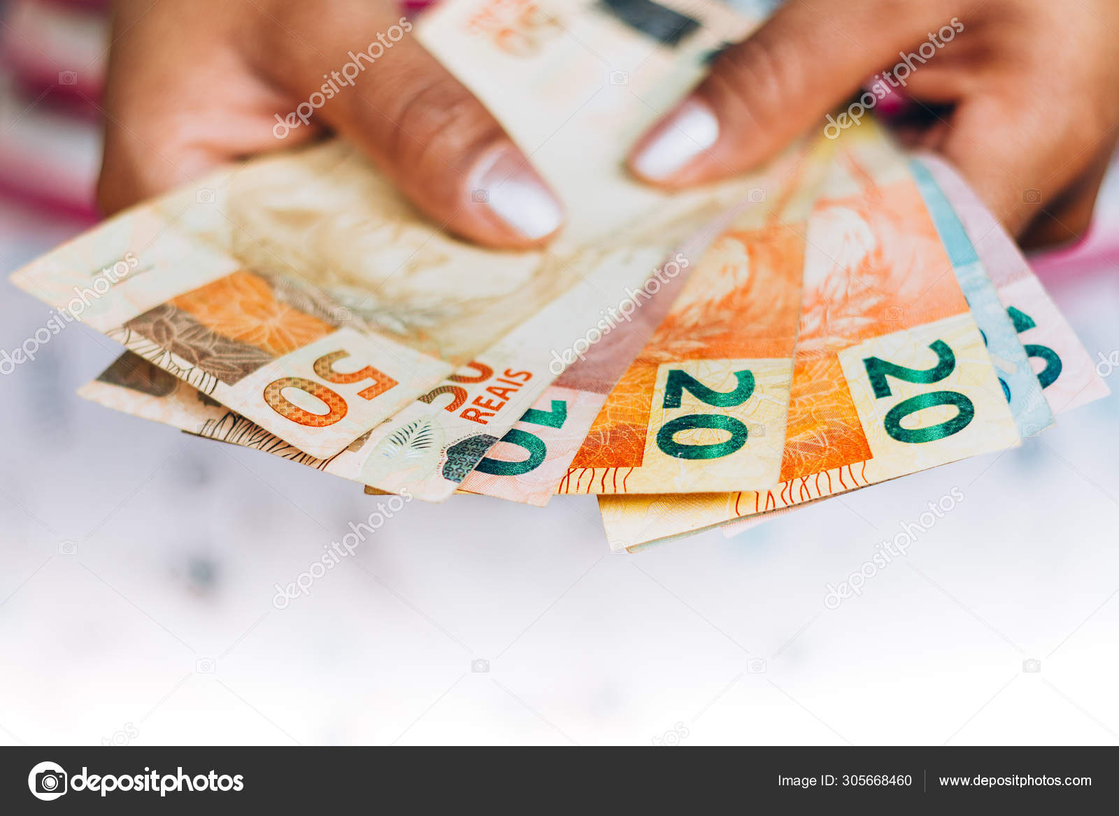 巴西货币- 真实票据- 巴西货币- 金融概念- 投资- 财富- 女性持有货币. —— 库存社论照片© rafapress #305668460