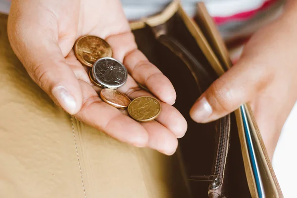 Femme tenant un portefeuille vide avec quelques pièces à la main - Concept de crise économique - Économiser pour la comptabilité financière . — Photo