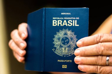 New Passport of the Federative Republic of Brazil - Mercosur Passport in your hand - Important document for foreign travel. clipart