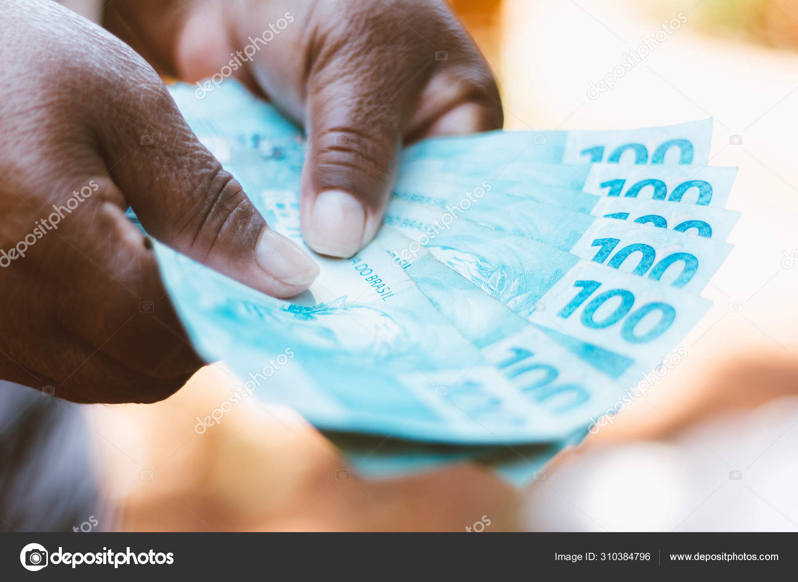 展示巴西货币的黑人妇女的手-- -- 100枚巴西雷亚尔钞票-- --经济概念-- --通货膨胀和商业. —— 库存社论照片© rafapress  #310384796