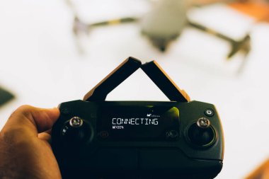 İHA pilotu, ekrandaki yazma eklentisiyle uzaktan kumandayı elinde tutuyor - kontrol antenleri çakıştı