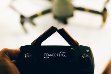İHA pilotu, ekrandaki yazma eklentisiyle uzaktan kumandayı elinde tutuyor - kontrol antenleri çakıştı