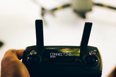 İHA pilotu ekrandaki yazma eklentisiyle uzaktan kumandayı elinde tutuyor - denetim antenleri kaldırıldı