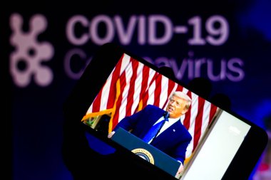 5 Haziran 2020, Brezilya. Amerika Birleşik Devletleri Başkanı Donald Trump 'ın akıllı telefondaki bu fotoğraf illüstrasyon konuşmasında. Arkaplan, COVID-19 (coronavirus).