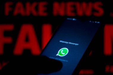 15 Haziran 2020, Brezilya. Bu resimde WhatsApp logosu bir akıllı telefon ve kırmızı alarm sözcüğünde bulanık arkaplanda gösterilir..