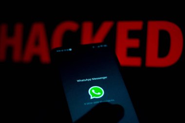 15 Haziran 2020, Brezilya. Bu resimde WhatsApp logosu bir akıllı telefon ve kırmızı uyarı kelimesi üzerinde bulanık arkaplanda HACKED gösterilir.