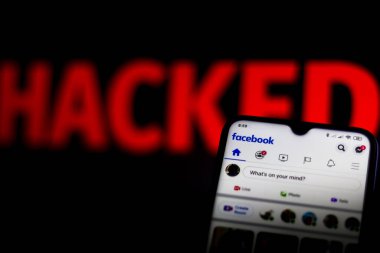 15 Haziran 2020, Brezilya. Bu resimde Facebook logosu bir akıllı telefon ve kırmızı uyarı kelimesi üzerinde bulanık arkaplanda HACKED gösterilir.