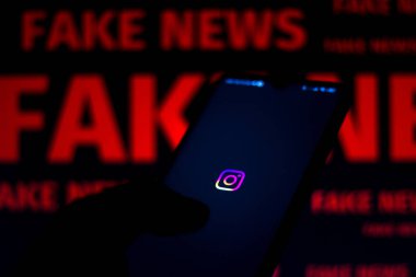 15 Haziran 2020, Brezilya. Bu resimde Instagram logosu bir akıllı telefon ve kırmızı alarm sözcüğünde bulanık arkaplanda gösterilir..